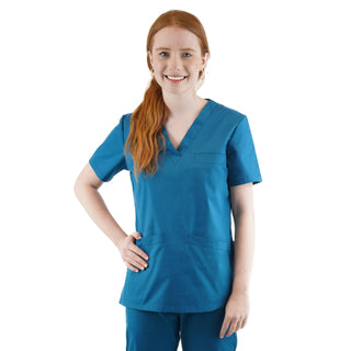 Damen-Schlupfkasack in der Farbe Meerblau, getragen von einer rothaarigen Frau, kombiniert mit passender Hose, freigestellt vor weißem Hintergrund.